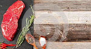 Raw meat, beef with spices for cooking on black board