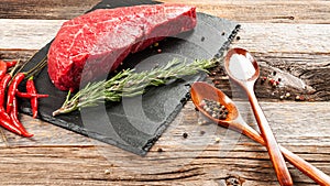 Raw meat, beef with spices for cooking on black board