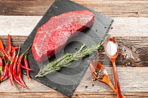 Raw meat, beef with spices for cooking on black board