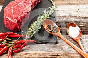 Raw meat, beef with spices for cooking on black board