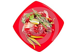 Raw meat chunk on red plate