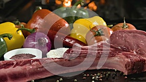 Raw meat with fresh vegetables on stone surface