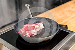 raw meat on frying pan