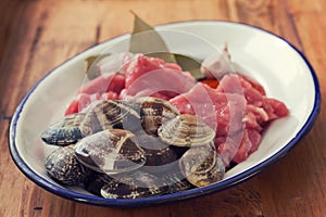 Raw meat with garlic and clams on dish