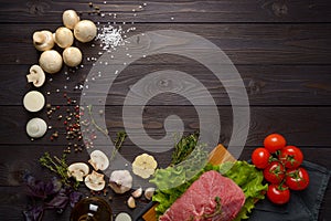 Raw meat with ingredients on a wooden background
