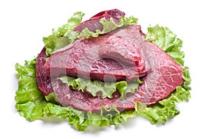 Raw meat on lettuce leaves.