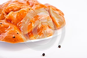 Raw meat marinated in spicy sauce close-up, isolated on white background with slices pepper