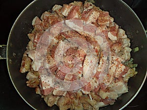 Raw meat with onions and spices in a frying pan