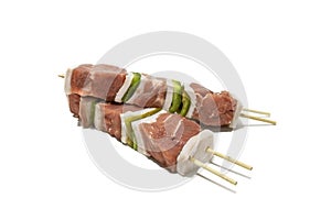 Raw meat and pepper skewers, isolated on a white background.