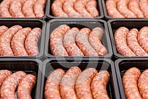Raw meat sausages in packing box