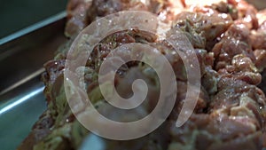 Raw meat on skewers for barbecue. Slow motion