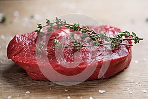 Raw meat with spices and herbs on table