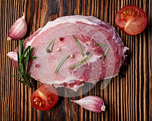 Raw meat, steak on a wooden Board. Spices, garlic, rosemary, peppers, tomato. Ready for cooking and roasting.