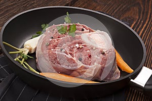 Raw meat with vegetables in pan.