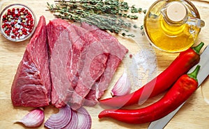 Raw meat, vegetables and spices . Fresh beef, peppers, red onion, garlic, thyme, olive oil