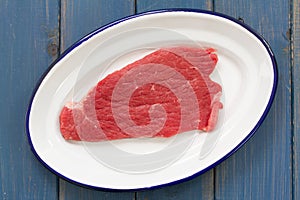 Raw meat on white dish