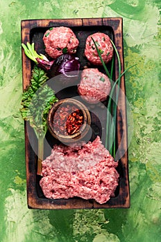 Raw meatballs on a chopping board