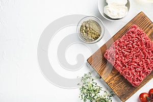 Raw meatballs made from ground beef ingredients, on white stone  background, top view flat lay, with copy space for text