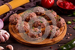 Raw meatballs, with micro greenery, with spices and ingredients, on a wooden table, homemade, rustic, no people,