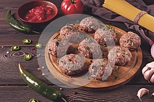 Raw meatballs, with micro greenery, with spices and ingredients, on a wooden table, homemade, rustic, no people,