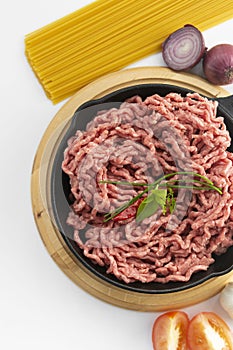 Raw micned beef uncooked meat with spaghetti basil onions white bacground spaghetti bolognaise top view