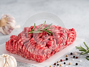 Raw minced beef on light gray cement background