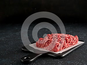 Raw minced beef on light gray cement background