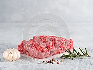 Raw minced beef on light gray cement background