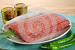 Raw minced meat in ceramic plate with green pepper