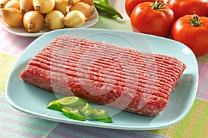 Raw minced meat in ceramic plate with green pepper