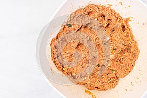 Raw minced meat mixture for meatballs in the bowl with copy space