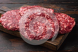 Raw Minced Steak Burgers from Beef Meat, on old dark  wooden table background