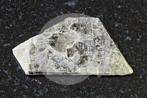 Raw muscovite common mica on black granite