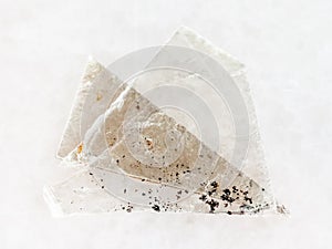 raw muscovite mica lamina on white marble