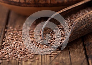 Raw natural organic linseed flax-seed in wooden spoon on wooden background. Healthy omega 3 product