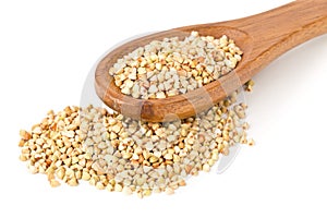 Raw, natural, uncooked buckwheat seed kernels in wooden spoon