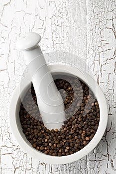 Raw, natural, unprocessed black pepper peppercorns in mortar photo