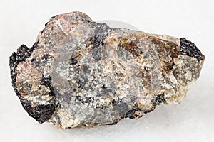 raw Nepheline stone with Ilmenite vein on white photo
