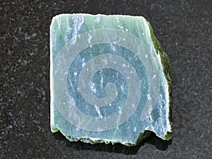 raw nephrite stone slab on dark background