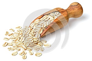 Raw oatmeal in the wooden scoop, isolated on white