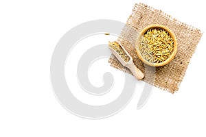 Raw oats in bowl and scoop on white background top view copy space