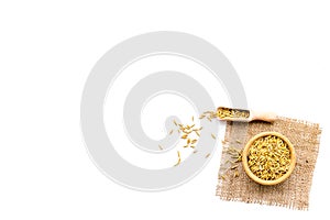 Raw oats in bowl and scoop on white background top view copy space