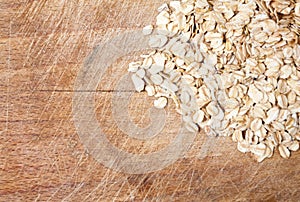 Raw oats wooden cutting board background.