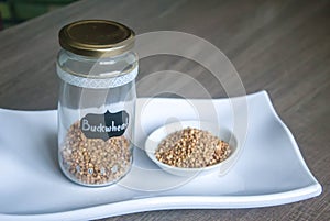 Raw organic Buckwheat in ceramic bowl on white plate