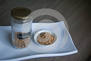 Raw organic Buckwheat in ceramic bowl on white plate