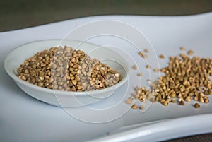 Raw organic Buckwheat in ceramic bowl on white plate