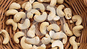 Raw organic cashew nuts in rattan wicker rustic kitchen bowl close up.