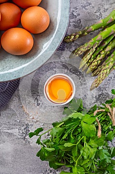 Raw organic egg with bunch of fresh parsley and salt