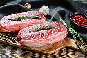 Raw organic meat Twagyu oyster top blade steak. Black wooden background. Top view