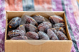 Raw and organic Medjool date fruit in paper box package